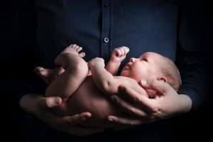 Persona che tiene in braccio un neonato